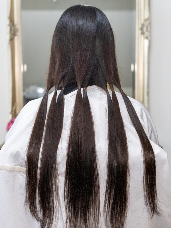 長い髪をいくつかの束に分け、それぞれをゴムで結んだ後ろ姿(イメージ)