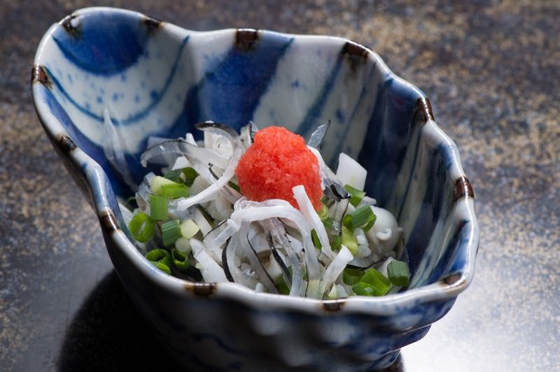 藍色の器に盛ったふぐ皮の湯引き。ねぎともみじおろしを添えて