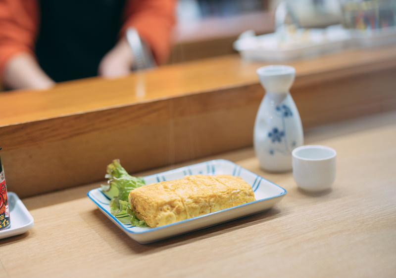 カウンターに置いた、だし巻き卵の皿と徳利・お猪口