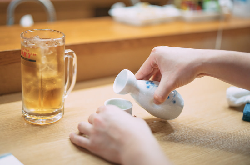 徳利からお猪口に酒を注ぐ手元