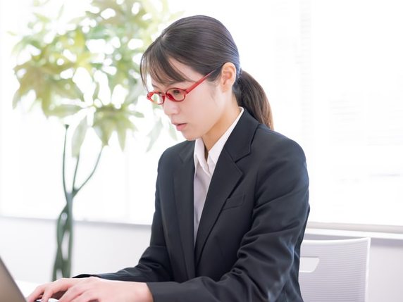 ノートパソコンで学習記録を入力する塾長(モデル)