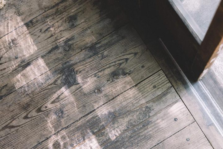 ガラス戸越しの光が映る、年季の入った木の縁側の床