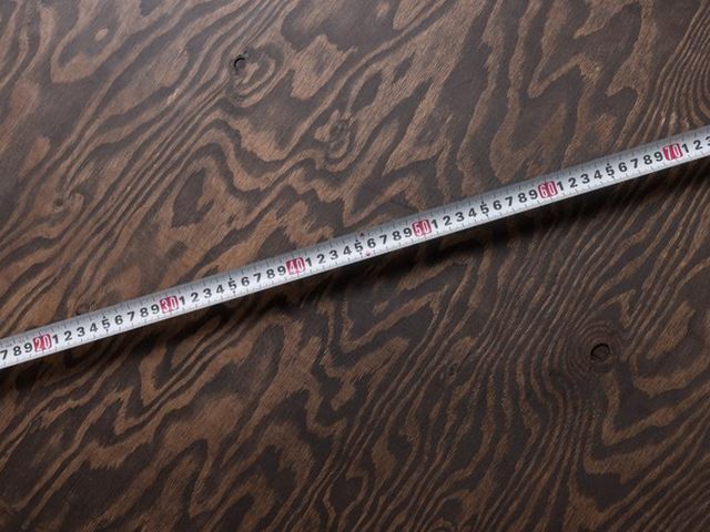 木目の板の上に、斜めに伸ばした白い巻き尺