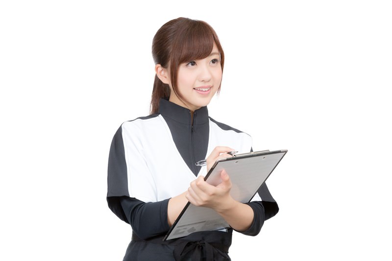 クリップボードに記入する院長のイメージ写真(モデル)