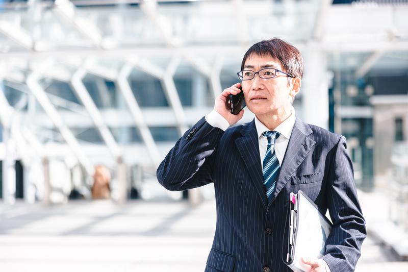 代表のイメージ写真(モデル)。携帯電話で話すスーツ姿の男性