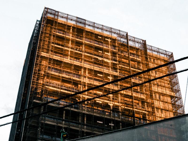 足場に囲まれた建設中の建物のイメージ写真